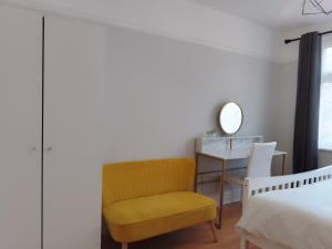 a bedroom with a yellow chair next to a bed at Surbiton Home with free parkings, Surbiton, Kingston upon Thames, Surrey, Greater London UK in Surbiton