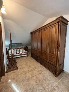 - une chambre avec un lit et une grande armoire en bois dans l'établissement Casa Flores, à Montecorto