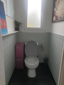 La salle de bains est pourvue de toilettes blanches et d'une fenêtre. dans l'établissement chambre chez Cathy, à Carbon-Blanc