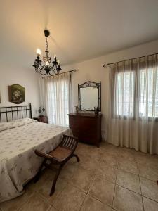 1 dormitorio con cama, espejo y silla en Casa Flores, en Montecorto
