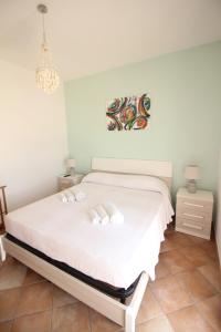 トッレ・サン・ジョヴァンニ・ウジェントにあるMare Di Pazzeのベッドルーム1室(白いベッド1台、白いタオル2枚付)