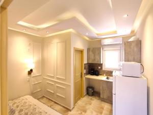 a kitchen with a white refrigerator and a window at Villa Miltiadis GreeceFilloxenia in Volos