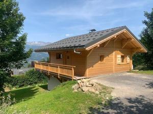 a large wooden cabin with a porch and a roof at Chalet le jardin de fées in Saint-Gervais-les-Bains