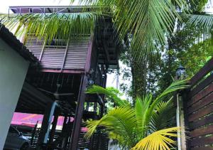 a building with a staircase and palm trees at Duduk #DesaMewah in Semenyih