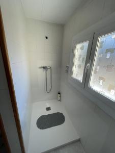 baño con ducha y suelo blanco y negro en Apartamento Fabian, en Guardiola de Berguedà