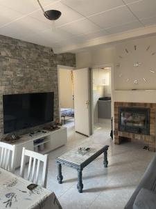 sala de estar con TV y chimenea en Apartamento Fabian, en Guardiola de Berguedà