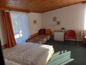 een slaapkamer met een bed, een raam en een stoel bij Penzion U Sochoru in Pec pod Sněžkou