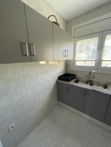 una cocina con armarios blancos y fregadero en Apartamento Fabian, en Guardiola de Berguedà