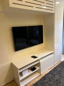 a living room with a flat screen tv on a wall at City Lux Apartman in Nyíregyháza