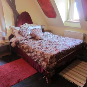 a bedroom with a bed with a red comforter at Pensiune Citadela Sighisoara in Sighişoara