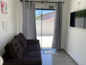uma sala de estar com um sofá e uma grande janela em Pousada Jeová Jireh em Penha