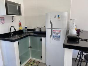 uma cozinha com um frigorífico branco e um lavatório em Pousada Jeová Jireh em Penha