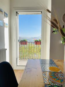 une salle à manger avec une table et une grande fenêtre dans l'établissement Loft panoramico Caltagirone centro, à Caltagirone