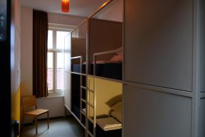 a bedroom with a closet with a bed and a window at Hostel & Bar De Basis in Zwolle
