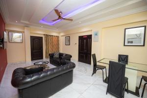 een woonkamer met een leren bank en een tafel bij Executive One Bedroom Furnished Apartment in Accra in Accra