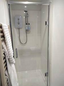 a shower with a glass door in a bathroom at Mervue Apartment, 4 Causeway View, Portrush in Portrush