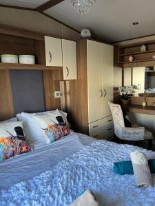 um quarto com uma cama grande e um cobertor azul em Playa la Casa em Lossiemouth