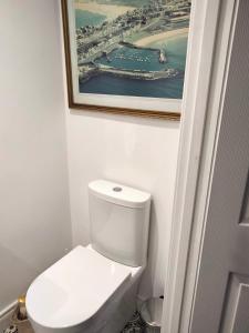 a bathroom with a toilet with a picture on the wall at Mervue Apartment, 4 Causeway View, Portrush in Portrush