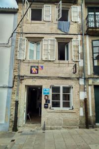 un antiguo edificio de ladrillo con ventanas y una puerta en Hostel SP 55 by Bossh! Hotels en Santiago de Compostela