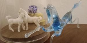 a glass figurine of horses on a table at Croix de la Liberté - Maison 3 chambres 