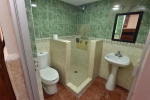 a bathroom with a toilet and a shower and a sink at Bed Bed Hotel Abasolo in Torreón