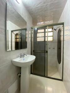 y baño con lavabo y ducha. en Hotel Fontibon en Bogotá