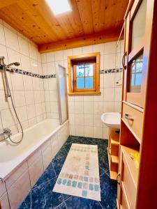 een badkamer met een bad en een wastafel bij Ferienhaus Kärnten Stückler in Hochrindl
