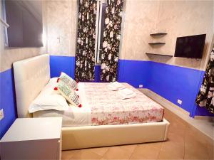 mały pokój z łóżkiem z niebieską ścianą w obiekcie Relaxon Guest House w Rzymie