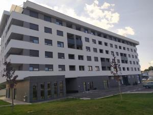 ein großes weißes Gebäude mit Parkplatz in der Unterkunft Apartman Eva in Zagreb