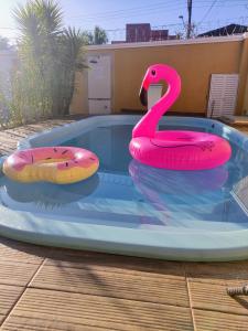 a pink swan float in a swimming pool at Pousada Marcos in Guarujá