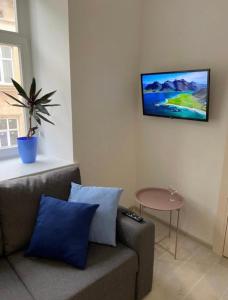 a living room with a couch and a tv on the wall at VIP Apartment Ploscha Rynok in Lviv