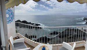 ein Balkon mit Stühlen und Blick auf das Meer in der Unterkunft Casa Angelmar in Puerto de Santiago + 13 Fotos