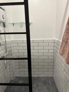 a bathroom with white subway tiles and a shower at Privée Homestay in Davao City