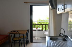 a kitchen with a table and a view of a balcony at Hotel Thisvi in Stalís