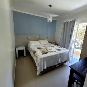 um quarto com uma cama grande e uma parede azul em Pousada Rota do Sol Bombinhas suítes com café e sem limpeza diaria em Bombinhas