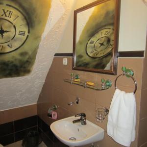 a bathroom with a sink and a clock on the wall at Pensiune Citadela Sighisoara in Sighişoara +42 photos