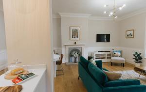 リッチモンドにあるSWALEDALE, OLD SCHOOL ROOMS - Luxury Apartment in Richmond, North Yorkshireのリビングルーム(青いソファ、暖炉付)