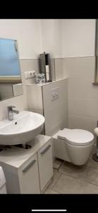 a white bathroom with a sink and a toilet at Szenetreff City in Würzburg