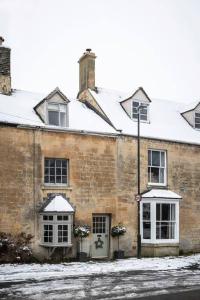 an old brick building with snow on the windows at Cosy Cottage in Moreton-in-Marsh in Moreton in Marsh