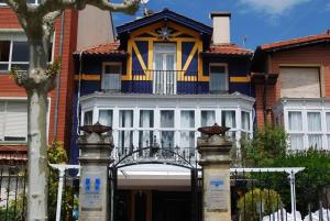 una casa azul y amarilla con una puerta delante en Casa de marinos UribeKosta, en Plentzia
