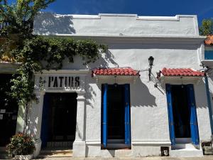 a white building with blue doors and a sign on it at Los Patios Hostel in Cartagena de Indias