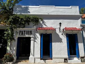 un edificio blanco con puertas azules y un cartel en él en Los Patios Hostel, en Cartagena de Indias