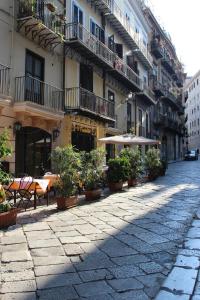 a cobblestone street with tables and umbrellas on a building at Apartment Basile in Palermo