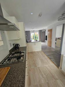 a kitchen with a stove and a counter top at Entire 2 Bedroom House Modern Stylish Luxury in Plymouth