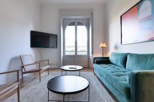 sala de estar con sofá verde y mesa en Adelaide Elegant apartments en Milán