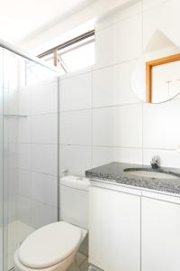 ein weißes Bad mit einem WC und einem Waschbecken in der Unterkunft Flat 1701 - PortoMar Home Club in Recife