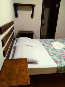 a bedroom with a bed and a wooden table at Hotel Rosalila in Copan Ruinas