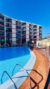 a swimming pool in front of a large building at Guinea Apartment in Playa del Ingles