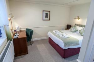 a hotel room with a bed and a desk at Shakespeare Inn in Kendal