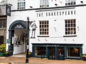 een wit gebouw met een bord aan de zijkant bij Shakespeare Inn in Kendal